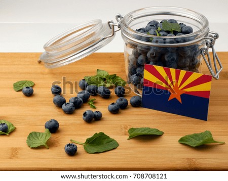 Arizona flag on a wooden plank with blueberries isolated on white