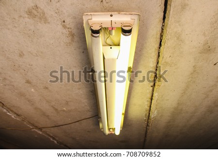 Fluorescent lamp, in a garage against a concrete ceiling