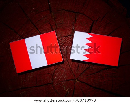 Peruvian flag with Bahraini flag on a tree stump isolated