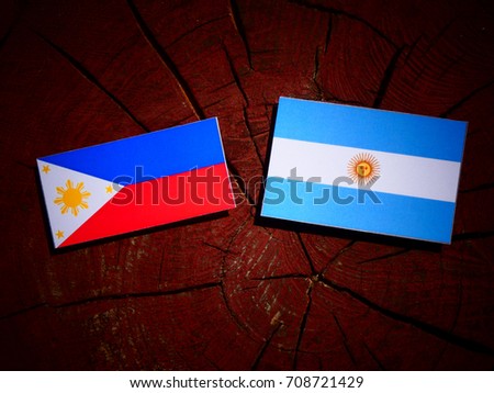 Philippines flag with Argentinian flag on a tree stump isolated