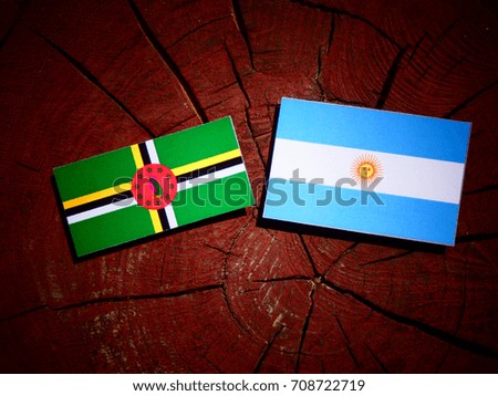 Dominica flag with Argentinian flag on a tree stump isolated