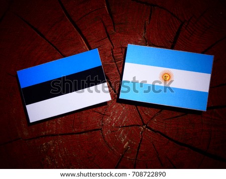 Estonia flag with Argentinian flag on a tree stump isolated