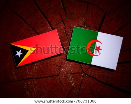 East Timorese flag with Algerian flag on a tree stump isolated