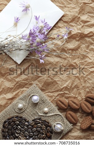 This are a letter, wild flowers, a biscuit and a picture on a crumpled paper