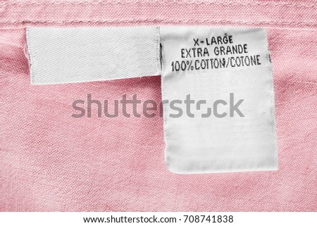 Fabric composition clothes label on pink cotton as a background
