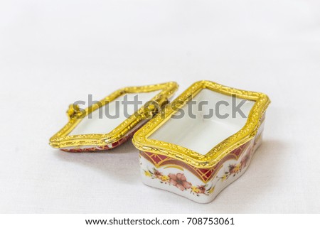 Tiny colorful jewel box with gold platted crimp in a white background. Macro with extremely shallow depth of field. Selective focus on the jewel box. chennai india tamil nadu