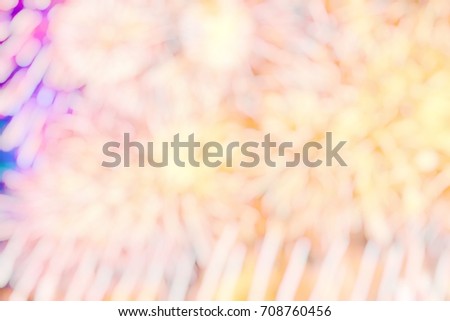 Blurred image of festive fireworks with flashes of yellow and red against the background of the night sky.