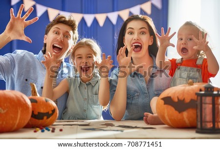 Mother, father and their daughters having fun at home. Happy Family preparing for Halloween.