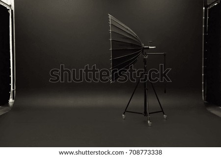 Big studio light standing on black studio backdrop