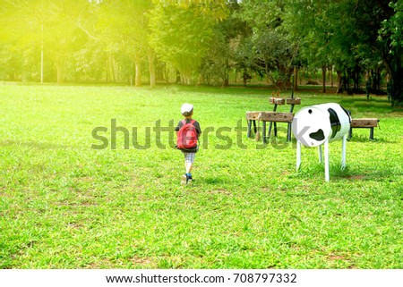 Little boy carry bag running in the park with beautiful sunrise in summer 