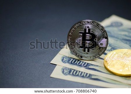 Photo of Silver bitcoin (new virtual currency) with 1000 Yen as a background .