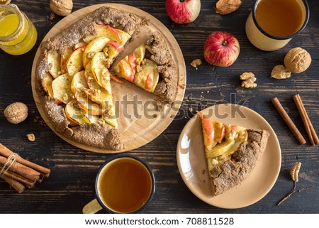 Autumn breakfast with tea and apple pie. Homemade seasonal organic food - apple galette with honey, walnuts and cinnamon for Thanksgiving day.