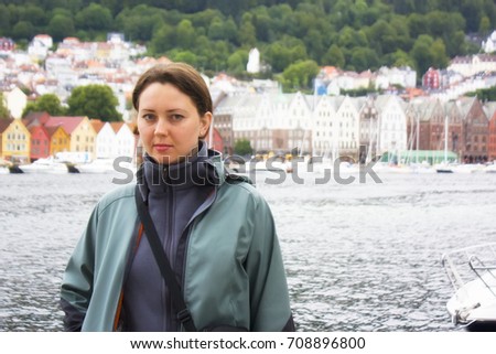 Beautiful tourist woman with a Bergen embaketment on a background. Norway . Travel picture