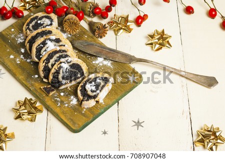 poppy seed rolls with an old dessert knife on aged wooden table