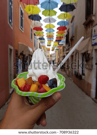 selective focus of an ice cream cup with blurry background with umbrellas of Novigrad Croatia Istria 