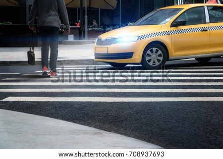 A taxi at a pedestrian crossing misses a person.