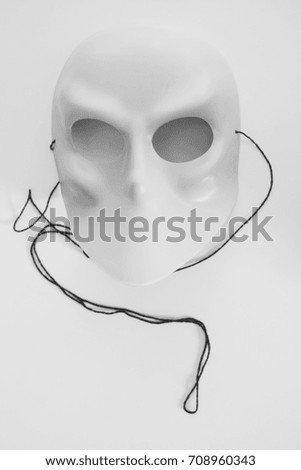Grey costume mask with black strings on an isolated white background
