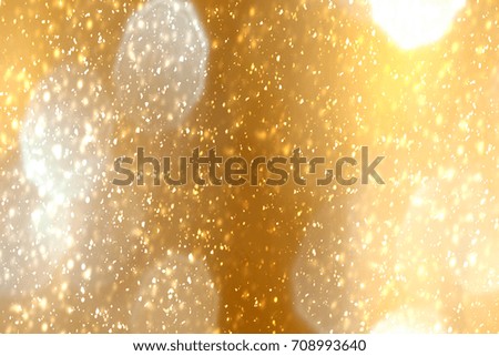 Golden abstract sparkles or glitter lights. Festive gold background.defocused circles bokeh or particles. Valentines day template