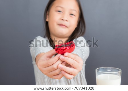 Cute little asian girl age 6 years eating sweet macarons