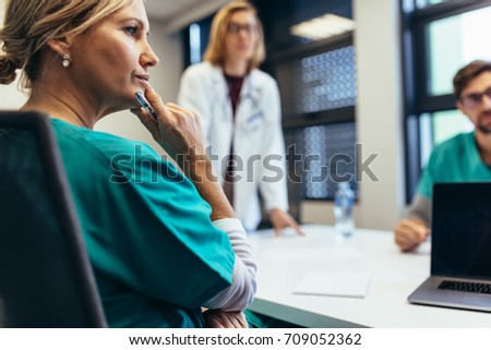 Female medical professional in meeting with colleagues. Doctor during meeting in the conference room. Royalty-Free Stock Photo #709052362