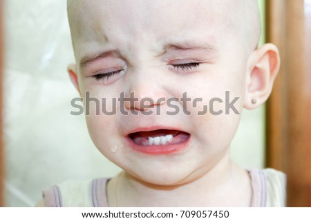 Teeth are cut in the baby. Pain and discomfort. Crying childish. Photo for your design.