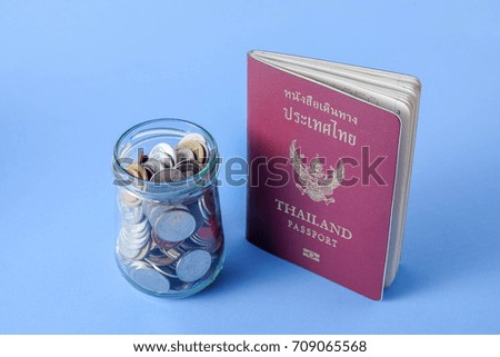Thailand passport  brown cover and money coin on blue paper background for traveling on holidays