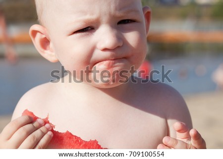 Little boy eating watermelon on the beach   