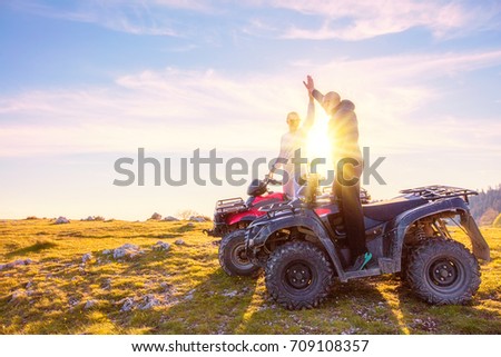 Rear view of young pair near atv. Man is showing something in distance to her girlfriend. Royalty-Free Stock Photo #709108357