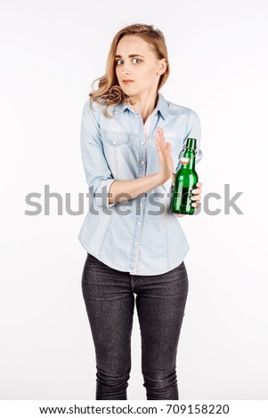 Female hand rejecting bottle with alcoholic beverage on white background. human emotion facial expression reaction attitude.  emotion expression and lifestyle concept.