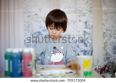 Cute little preschool boy, drawing picture at home, wintertime
