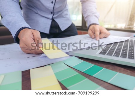 interior Creative creativity graphic designer working with graphics laptop, blueprint and colour chart at workplace on wooden desk , colour ideas style concept.