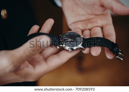 Man holding a watch in the hands before to put it on