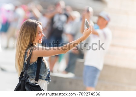 Pretty teenager taking a selfie with her mobile phone outdoor in the city