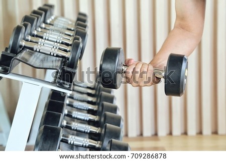 Close up of man holding weight in gym. fitness concept. holding dumbbell in fitness center. concept of healthy