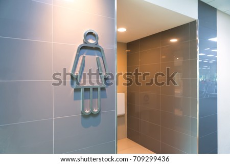 modern public woman toilet sign on granite wall tile at the entrance