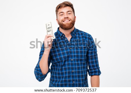 Happy bearded man holding money in hand over gray background