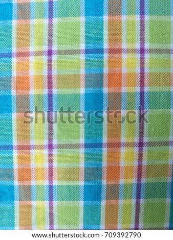 Colorful checkered fabric texture as background.