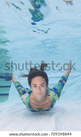 Woman model smiling underneath the surface.