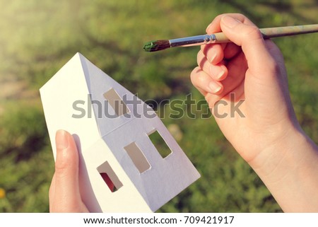 artist paints the layout of the house with a fine tassel / green color solution