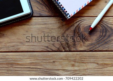 Notebook, tablet pc, pen on office table. Wooden background with copy space for text. Workspace. Top view