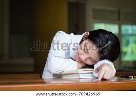 Asian woman taking a nap on the table during work