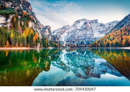 First snow on Braies Lake. Colorful autumn landscape in Italian Alps, Naturpark Fanes-Sennes-Prags, Dolomite, Italy, Europe. Beauty of nature concept background.  Royalty-Free Stock Photo #709430047
