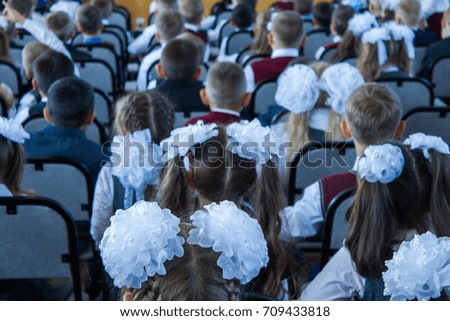 many children sit dressed in the assembly hall at a concert dedicated to the Day of Knowledge Day on September 1. the picture is taken from the back