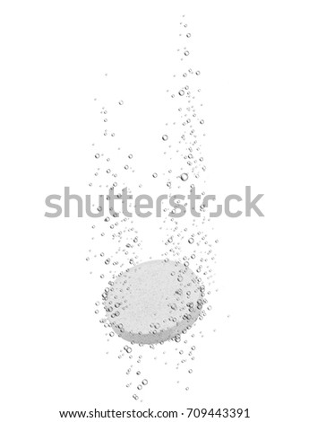 Medical pill dissolves in water on white background 