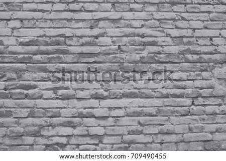 Old brick wall covered with neutral gray lime. Trending backdrop for creative projects.