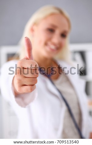 Beautiful smiling female doctor showing OK or confirm sign with thumb up closeup. High level therapeutist consultation, best treatment, healthy lifestyle, satisfied patient, physical exam concept