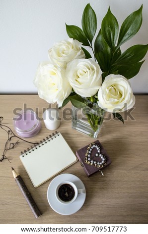 Creative design of the workspace. Flowers, candles, casket, pencil, coffee and empty bag with space for text on a wooden table. View from above.