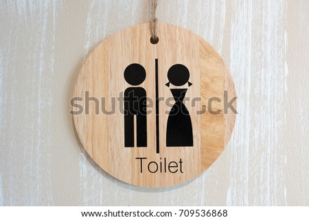 Beautiful sign in front of the bathroom is made of wood.