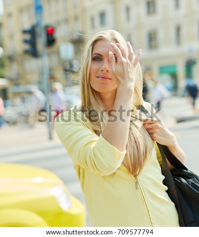 Attractive young blonde woman walking in the city at springtime.