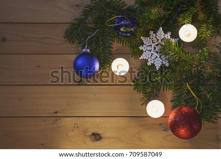 Christmas themed background with candles,decorations and some fir branches. Picture is in matt tones.